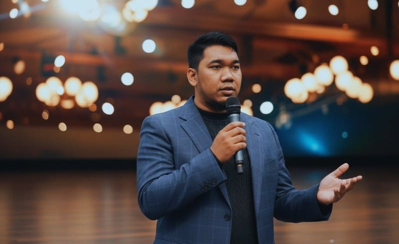 Mazidul Akhmal MA speaking on stage at a business training event